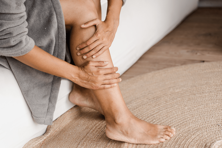 woman holding leg in pain from dvt